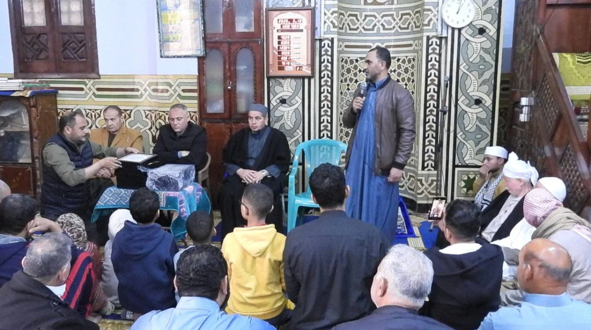 أسامة حسني يسلم شهادة تكريم لأحد الأطفال من حفظة القرآن في قرية الغار